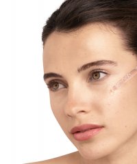 Illustration einer Frau, die ein Serum auf ihr Gesicht aufträgt, betont die Verwendung von Hyaluronsäure für Hautpflegevorteile.